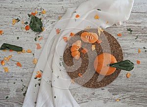 Tangerines on cork plate and white table background