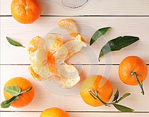 Tangerines with green leaves on wooden background