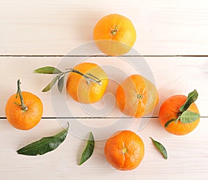 Tangerines with green leaves on wooden background