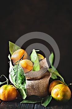 Tangerines with leaves on an old fashioned country table. Selective focus. Vertical.