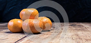 Tangerines (oranges, mandarins, clementines, citrus fruits) over rustic wooden background, copy space