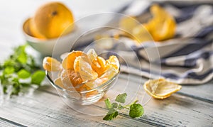 Tangerines with peel and mellisa herbs on table. Ripe fresh tropical fruit on wooden board