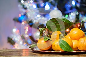 tangerines on the table against the background of the Christmas tree