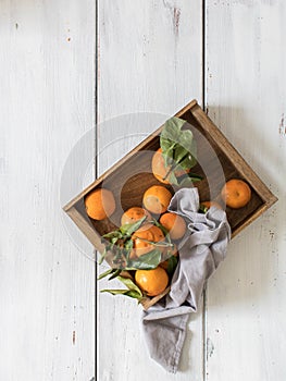 Tangerines in wooden box. White background
