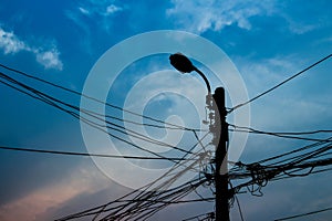 Tangle cable and electricity post on sunset background