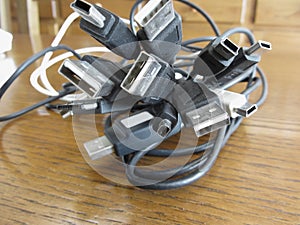 Tangle of dusty computer cables with sockets on the table
