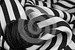 Tangle of knitted thread on striped fabric, black and white photo