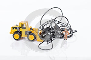 Tangled earphones cable with miniature worker and front loader truck isolate on white background