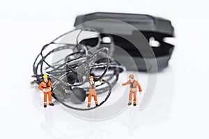 Tangled earphones cable with miniature worker isolate on white background