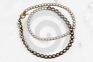 Tangled necklace from faceted nacre beads on gray