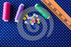 Tangles of threads and colored buttons on the blue fabric