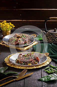 Tangra Chili Chicken served in a dish isolated on dark background side view food
