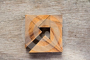 Tangram puzzle as arrow in square shape on wooden background & x28;Co photo