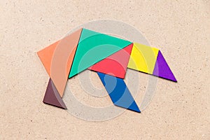 Tangram puzzle in bear shape on wood background