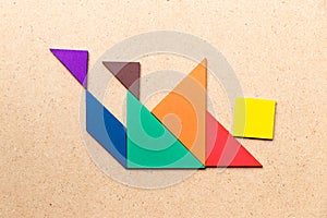 Tangram puzzle in falling man shape on wood background Concept for business crisis