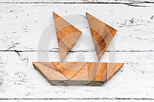 Tangram puzzle in sail boat or yacht shape on white wood background Concept for start the business or new journey