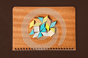 Tangram puzzle shape on brown notebook, use for business and education concept