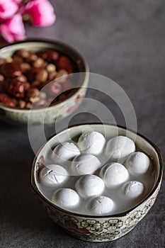 Tangyuan, peanuts, red dates and flowers on the table