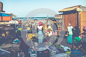 TANJI, THE GAMBIA - NOVEMBER 21, 2019: People carrying fish from the boats to the beach on Tanji, Gambia, West Africa