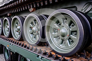 Tank armoured vehicle loaded at truck, detail to wheels on continuous tread tracks