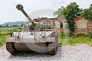 Tank in front of broken house