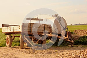 The tank spreader and trailer on a rural field.