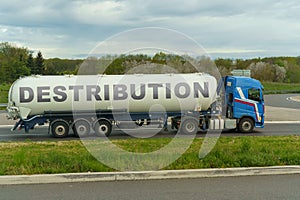 On a tank truck driving along the road there is an inscription - Destribution