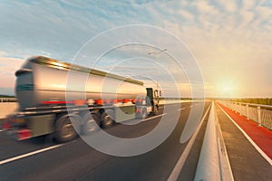 Tank truck on the empty highway at sunset