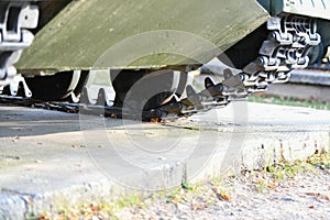 Tank wheels close-up. Iron tracks of a heavy military tank. Iron caterpillars and wheels of a military heavy tank. View of the