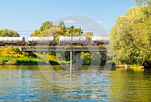 Tanker cars of the train on bridge over river Vah