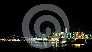 Tanker Docking Near City On Rainy Night