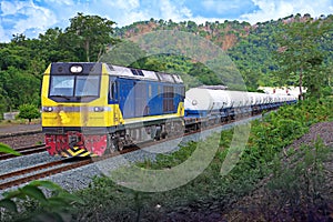 Tanker-freight train by diesel locomotive on the hillside railway.