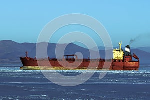 Tanker in the ice sea against the shore