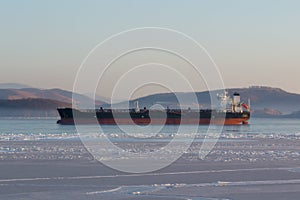 Tanker in the ice sea against the shore