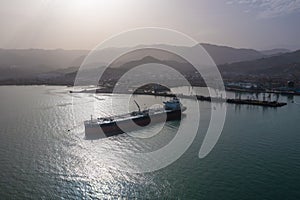 Tanker moored at oil terminal, intricate part of global petro resource trade, aerial view from drone. Key hub in