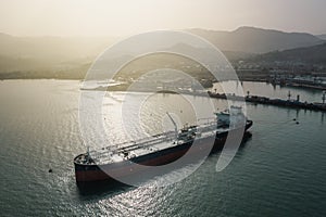 Tanker moored at oil terminal, intricate part of global petro resource trade, aerial view from drone. Key hub in