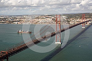 Tanker ship passes under the The 25 April bridge