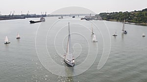 Tanker ship and sailboat on river. Aerial view. Sailboats and a tanker