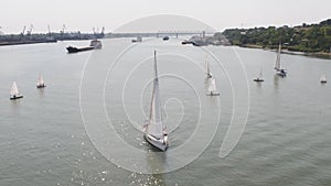 Tanker ship and sailboat on river. Aerial view. Sailboats and a tanker photo