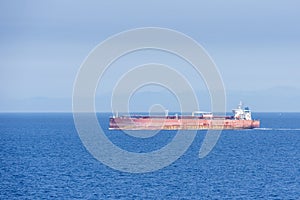 Tanker ship sailing through blue and calm Mediterranean Sea.