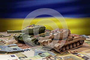 Tanks on euro banknotes on the background of the flag of Ukraine. Concept: military and financial assistance to Ukraine,