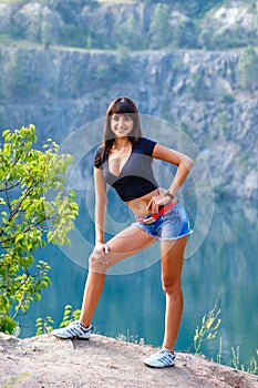 Tanned brunette woman walking on the shore of a mountain la