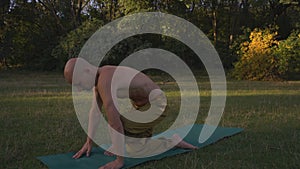 Tanned Guy with Naked Torso Performs Yoga Asanas, Do Exercise Twist In the morning in City Park