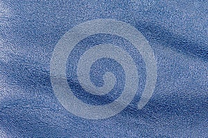 Tanned leather is painted blue. Blue leather background macro