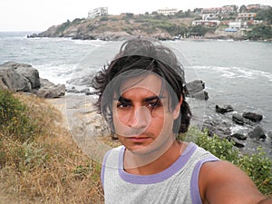 Tanned man in a sea resort posing for selfie