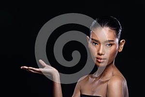 Tanned skin young fashion Asian woman model present showing empty copy space on her hand palm