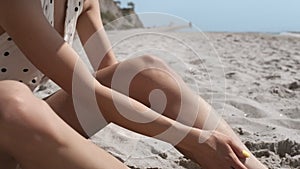 Tanned woman body wearing polka dot swimsuit on sand beautiful seacoast close up