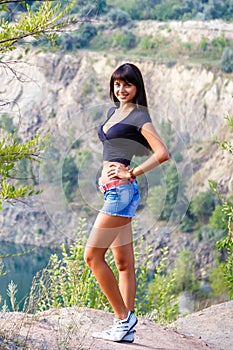 Tanned young brunette girl walking on the shore of a mountain la