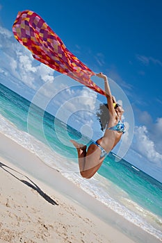 Tanned young europen women with red pareo jump