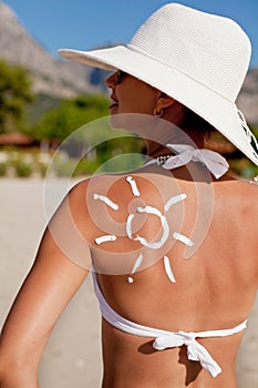 Tanning lotion on woman's shoulder.